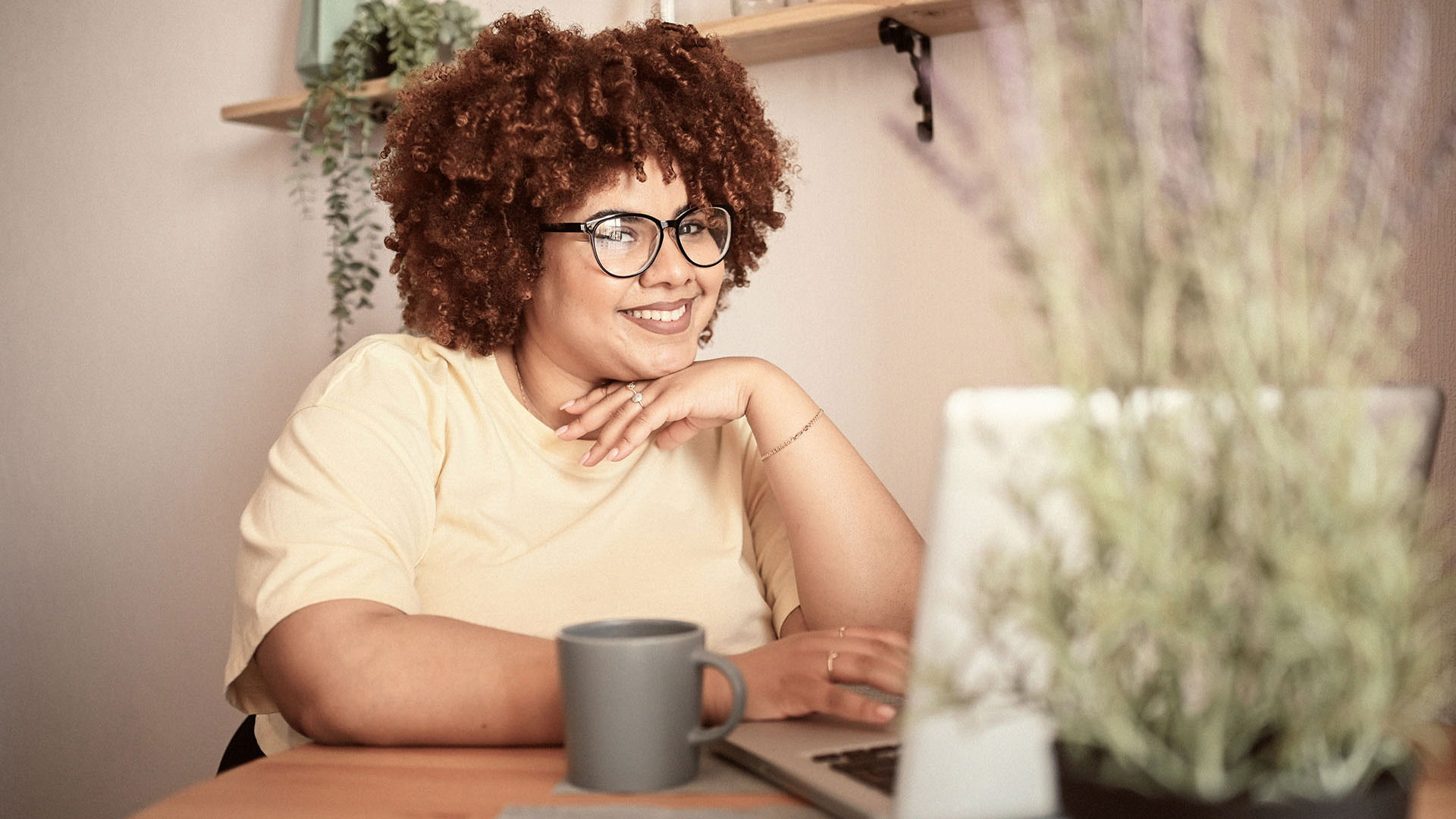young woman wearing glasses looking at laptop