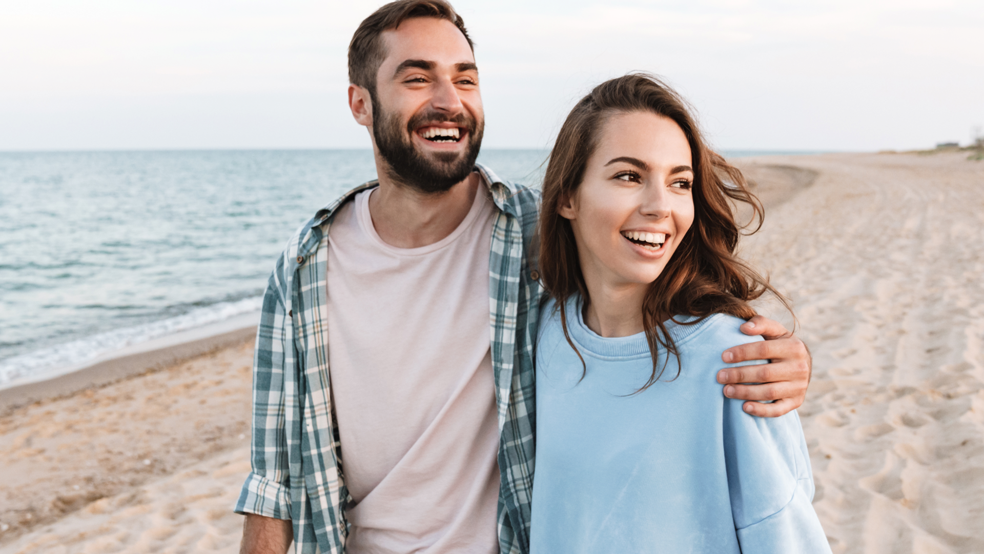 Couple walking together on the beach after saving at tax time with their health insurance hospital cover