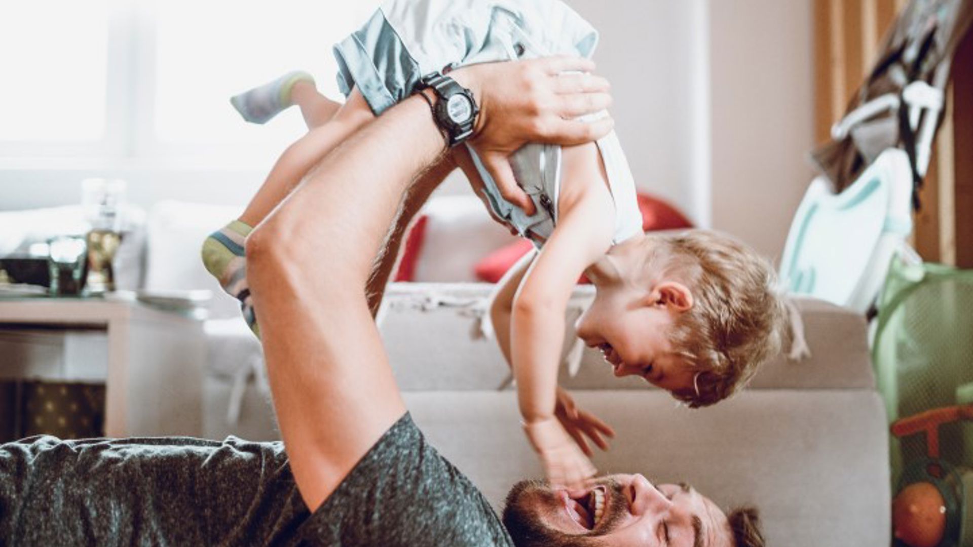 Dad playing with his baby after going on parent leave working at GMHBA