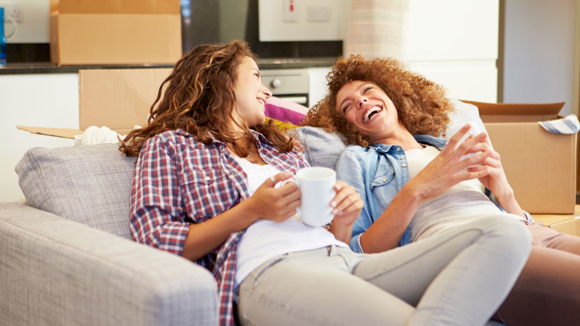 A couple laughing on the couch after making the switch to GMHBA