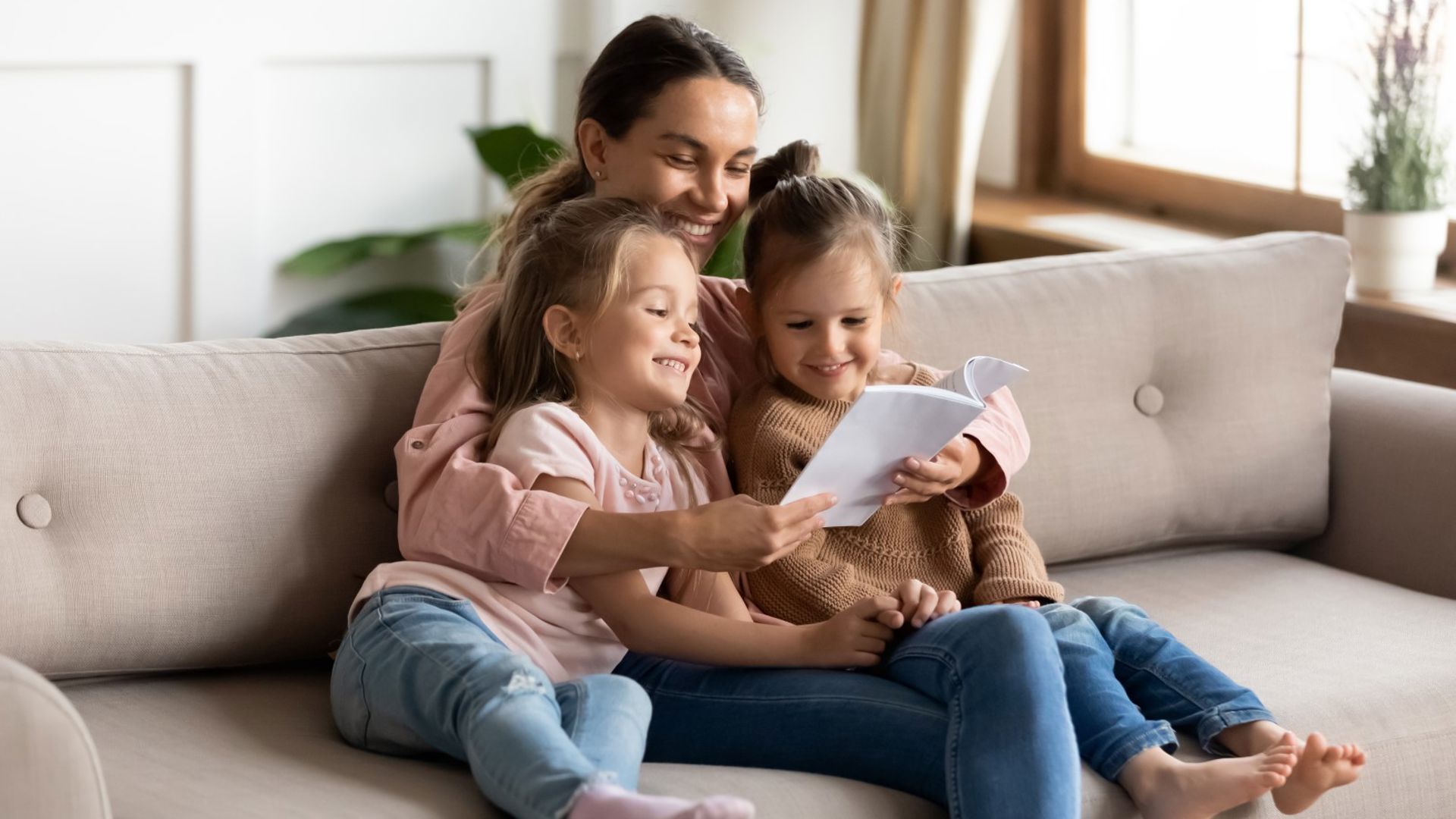 Mother sitting reading with her two children, relaxing whilst learning that GMHBA have freezed their premiums.jpg