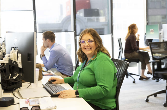 Happy GMHBA employee at desk in light filled office
