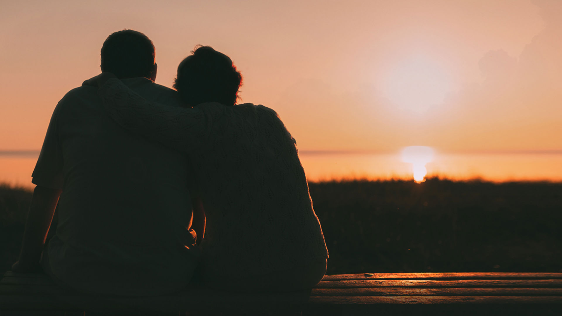Couple cuddling in darkness at sunset