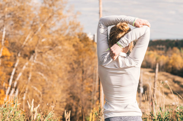 Woman stretching her back in field