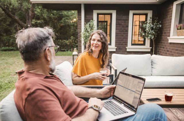 middle aged couple enjoying a coffee on their deck chatting about health insurance