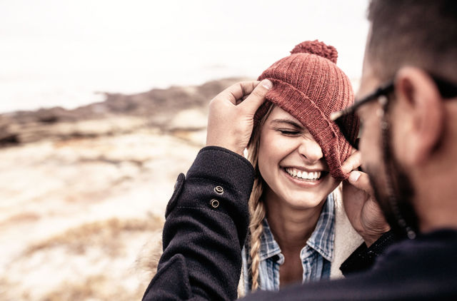 Laughing GMHBA Extras member and partner playing with her beanie