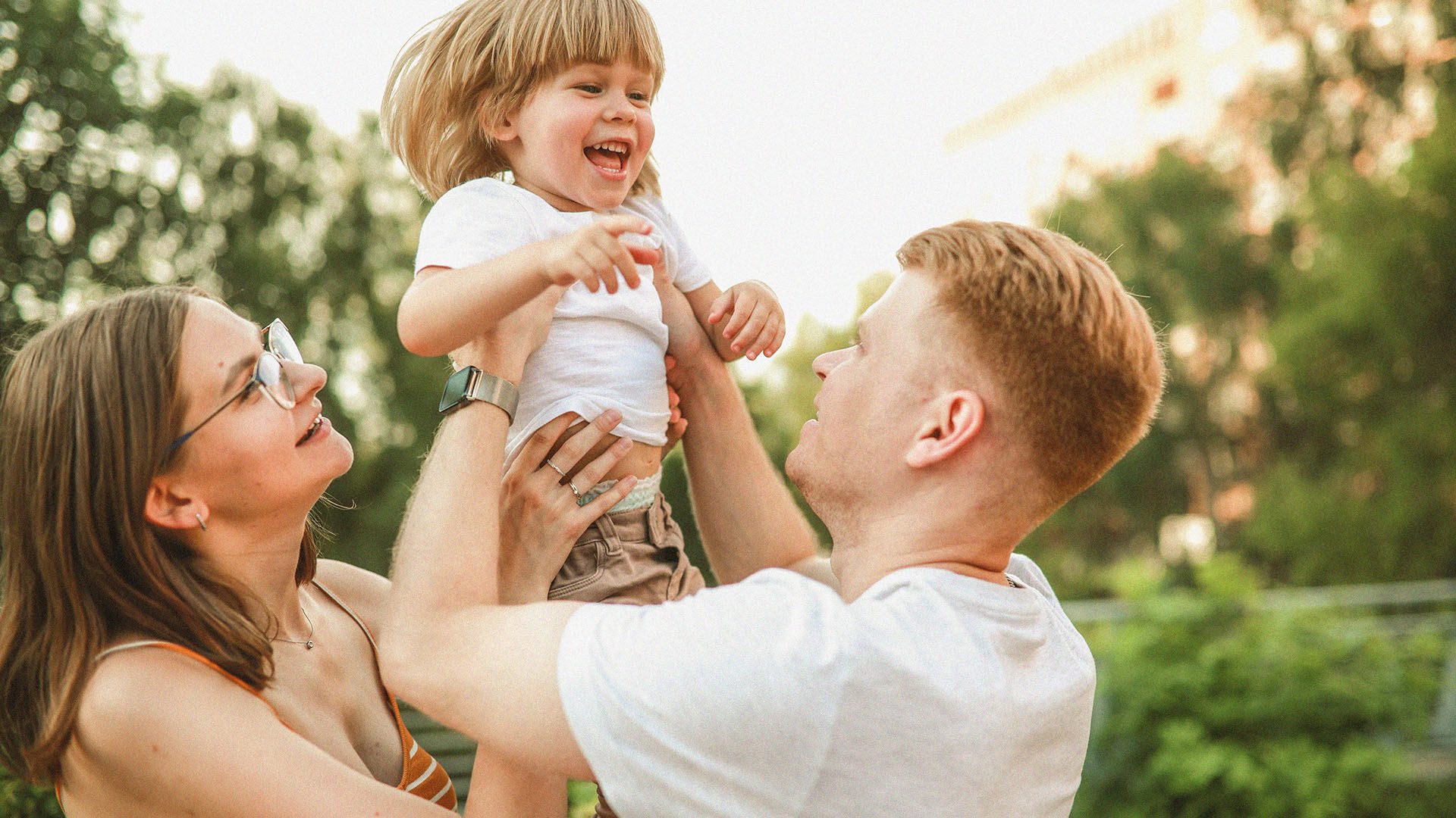 Young family with toddler playing in the sunshine.jpg