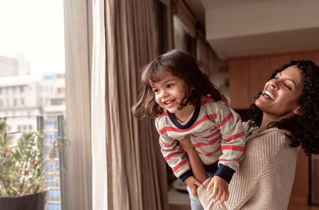 Mother and daughter playing near window